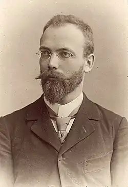 Konrad Zingerle mit Brille, Vollbart und dunklem Anzug