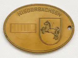 Kriminaldienstmarke der Polizei Niedersachsen mit Landeswappen Sachsenross (Rückseite) – Nummer mit Bildbearbeitung entfernt