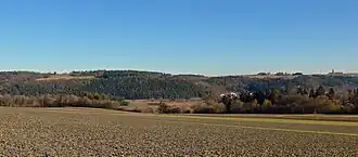Kühlenberg von Westen, vom Gewann Buchhalde nördlich von Mindersbach. Links der alte Wasserturm, nahe dem höchsten Punkt. Rechts der neue Wasserturm. Etwas rechts der Bildmitte die höchsten Häuser von Emmingen, davor das Nagoldtal.