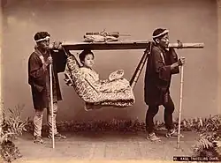 Eine Fotografie, die von Kimbei aufgenommen wurde und ebenfalls Sänftenträger zeigt. Sie orientiert sich kompositorisch an der Aufnahme Beatos.