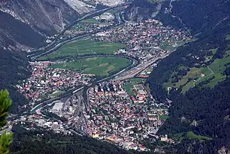 Die Stadt Landeck in Tirol mit der Trasse der Arlbergbahn (im Vordergrund) und dem Bahnhof Landeck-Zams sowie der Inntal Autobahn A&nbsp;12.