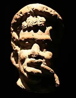 Bekränzter Mann mit negroiden Zügen.