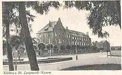 Photographie einer Photopostkarte aus dem Jahre 1910, die einen Block (Magazingebäude) des Korpsbekleidungsamts vom (später so benannten) Langemarckplatz aus zeigt (Blickrichtung: Westen). Bildunterschrift unter der Postkarte: „Koblenz a. Rh. Langemarck -Kaserne.“