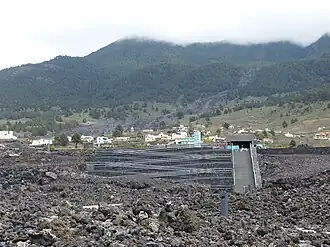 Lavafeld des Llano del Banco-Vulkans, Be­su­cher­zent­rum (im Bau), im Hintergrund der Anfang des La­va­stroms