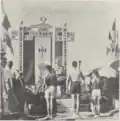 Sportveranstaltung in Französisch-Indochina vor der französischen Nationalflagge mit Francisque