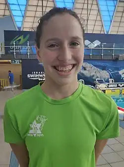 Polonsky trägt ein grünes T-Shirt.