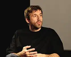 Levin Peter sitzend vor Filmleinwand während Filmgespräch