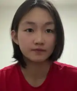 Li Bingjie trägt ein rotes T-Shirt und schaut frontal in die Kamera.