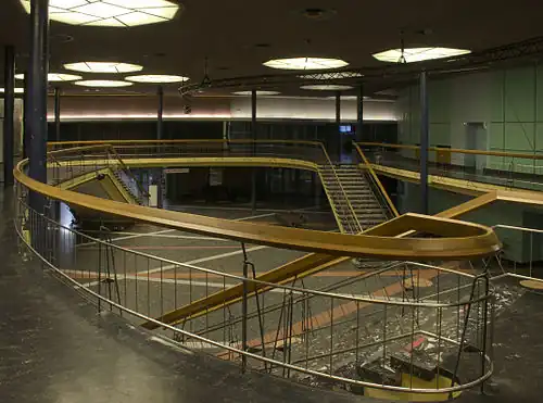 Blick vom oberen Bereich des Foyers auf eine Treppe und den unteren Bereich