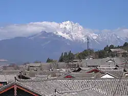 Blick über die Dächer von Lijiang auf den Yulong Xueshan (玉龙雪山 – „Jadedrachen-Schneeberg“, 5596 Meter)