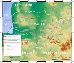 Landkarte Litauens mit farbiger Markierung topografischer Unterschiede. Hauptstadt, Distrikthauptstadt, Stadt, Wallfahrtsort und Flughafen sind eingezeichnet und in der Legende links unten erläutert.