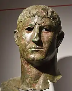 Links Kopf der Statue, die Lucius Cornelius Pusio darstellt; rechts Inschrift, die die Laufbahn von Lucius Cornelius Pusio beinhaltet