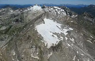 Luckenkogel mit Luckenkees (mittig vorne), rechts daneben das Felshorn des Äußeren Knappentrögers, im Hintergrund Landeggkopf, Stubacher Sonnblick mit Prägratkees, Granatspitze, Kalser Bärenkopf, Knaudl mit Überrest des Landeggkees und die Aderspitze (von links nach rechts, Gletscherstand Juli 2022)