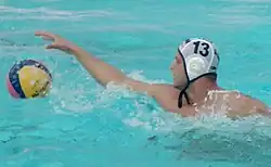 Luka Lončar ist im Wasser und greift nach dem Ball. Auf der weißen Bademütze steht seine Nummer 13.