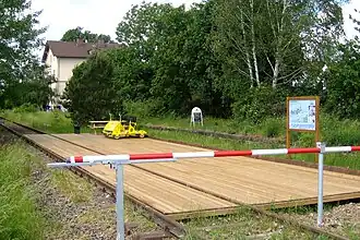 ehemaliges Bahnhofsgebäude (hinten) mit Draisinenstation Lustadt-Mitte im Vordergrund