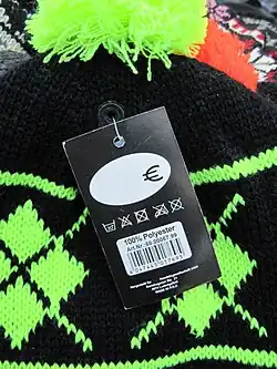 Mit einer Etikettierpistole angebrachtes Etikett an einer Wollmütze