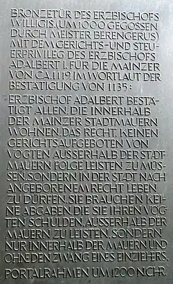 Gerichts- und Steuerprivileg im Wortlaut der Bestätigung von 1135. Die moderne Tafel ist neben dem Marktportal angebracht.