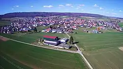 Auf dem Bild ist Schröck(Marburg) aus der Vogelperspektive. Der Blick geht in Richtung Norden. Zu sehen ist neben vielen Häusern auch die Kirche
