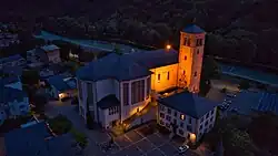 Martinskirche am Abend, im unteren Teil des Gebäudes die Bru­der-Klaus-Kapelle, rechts unten das Pfarrhaus