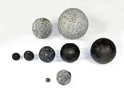 Historische Geschützkugeln aus Stein (oben) Eisen (Mitte) und Blei (unten)