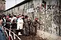 Mauerspechte brechen an der Mauer nahe dem Reichstagsgebäude Stücke heraus, Ende 1989