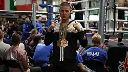 Maurizio Granieri mit zwei Goldmedaillen als ISKA-Doppelweltmeister 2023, stehend vor einem Boxring in München