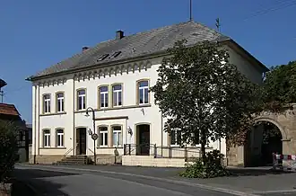 Ehemaliges evangelisches Schul- und Pfarrhaus, ein repräsentativer Walmdachbau, um 1850/60 erbaut.