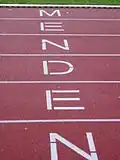 „Menden“-Schriftzug auf der Laufbahn des Huckenohlstadions