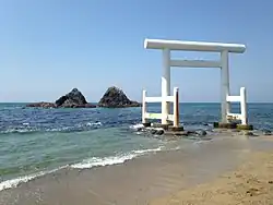 Weißes Torii auf dem Strand von Futamigaura