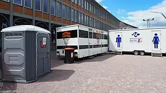 Eine bodenebene Einzelkabine ergänzt Toilettenwagen mit Treppen.