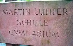 Name der Schule als Sandsteinrelief