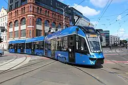 Das Fahrzeug ist von rechts vorne fotografiert. Mit Ausnahme der fehlenden zusätzlichen Linienanzeige auf dem Dach entspricht die Form dem LF 02 AC. Die Lackierung ist hauptsächlich metallic-hellblau gehalten.