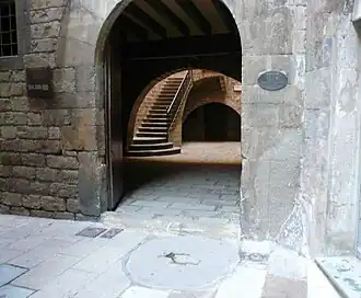 Der Mühlstein vor dem Eingang des Gebäudes Carrer Paradís Nr. 10 markiert den höchsten Punkt der Erhebung. Hier ist das Centre Excursionista de Catalunya (CEC) beheimatet, ein von Alpinisten im 19. Jahrhundert gegründeter Verein.