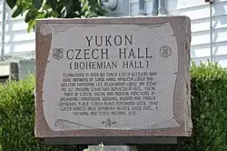 Eine steinerne Gedenktafel mit der Überschrift "Yukon Czech Hall: Bohemian Hall" und der Beschreibung des Gebäudes