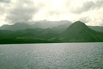 Wolkenumhüllter Morne Diablotins von der Küste gesehen, im rechten Vordergrund der Morne Espagnol (Barbers Rock)