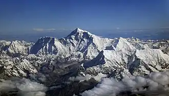 Die breite Südwand des Chamlang (vorne rechts, Hauptgipfel am linken Gratende) erscheint klein im Vergleich zur dahinterliegenden Nuptse-Lhotse-Südwand, die in der Bildmitte vom Mount Everest noch überragt wird.