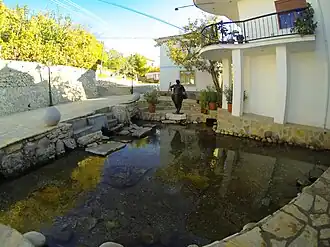 Ortszentrum mit Teich und Statue von Teto Ollga