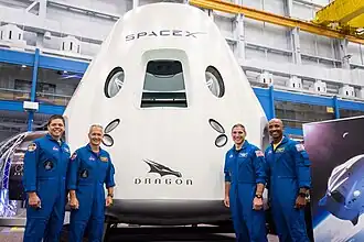 Crew und Ersatzcrew von SpX-DM2 vor einem Crew Dragon-Mockup