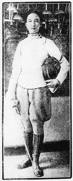 Nadine Hwang ist auf einer Fotografie in schwarz-weiß zu sehen. Sie hält in der rechten Hand einen Degen und in der linken einen Gesichtsschutz.