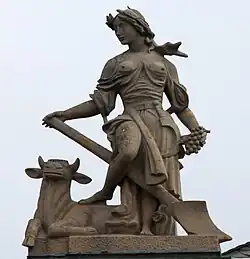 5. Ackerbau – Ährenkranz, Kuh, Spaten, Sichel, Trauben.