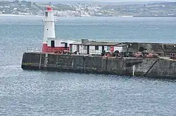 Das Gebäude des Observatoriums 2011. Eine rot-weiße Hütte mit Flachdach auf einem Pier