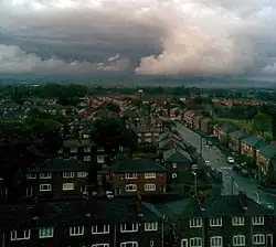 Newton Heath, Stadtteil von Manchester, Blickrichtung Osten, vor allem auf zweistöckige Wohnbesiedlung und gerade über der Stadt befindlichen dichten, sich auftürmenden Regenwolken