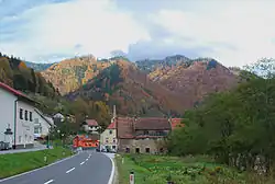 Bewaldete steile Berghänge säumen den Verlauf der Drau bei Ožbalt