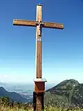 Gipfelkreuz des Ochsenälpeleskopf; Im Hintergrund: Füssen und der Hohe Straußberg