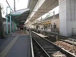 Haltestelle der Straßenbahn, darüber der Shinkansen-Viadukt
