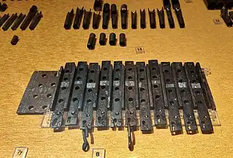 Die Windladenoberplatte mit ihren 4 × 13 Löchern, darauf liegend 11 der 13 Tonschleifen, mit denen sich jeweils vier Löcher der Windladenoberplatte öffnen oder verschließen ließen