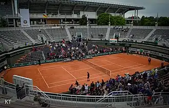 Der 2019 abgerissene Court n°1 (Mai 2019). Er war wegen seiner Form als Stierkampfarena bekannt.[28]