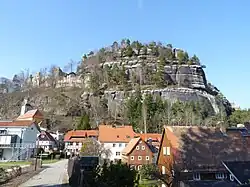 Umgebindehäuser in Oybin mit dem gleichnamigen Berg und einem Teil der Klosterruine