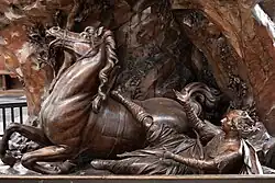 Die bräunlich glänzende Plastik eines vom Pferd gestützten Reiters