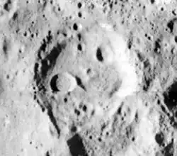 Schwarzweißbild eines quaderförmigen Kraters auf einer steinartigen hellen Oberfläche.